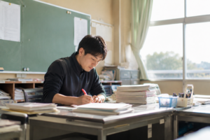 学級通信 2学期の書き出し 教室で通信を書く担任の先生