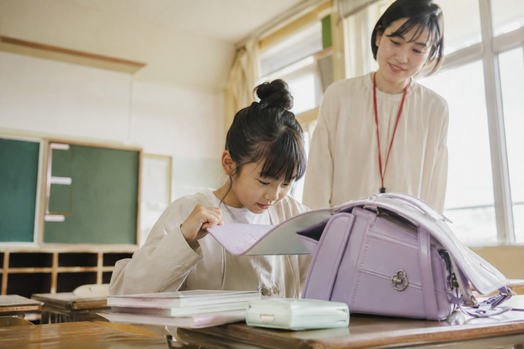 忘れ物が多い子 対応 ランドセルの持ち物を確認する小学生と教師